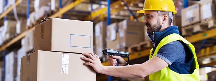 Warehouse worker scanning stack of boxes